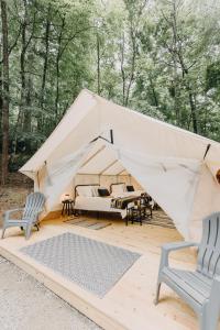 uma tenda de lona com duas cadeiras e uma cama em Timberline Glamping at Unicoi State Park em Helen