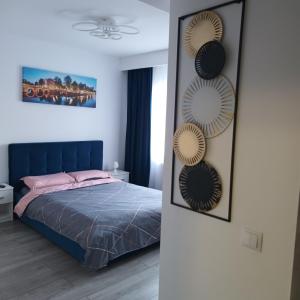 a bedroom with a bed with a blue headboard and mirrors at Studio Acasă in Sibiu
