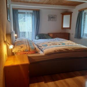 1 dormitorio con cama, mesa y ventana en Landgasthaus Birkegg, en Leutasch