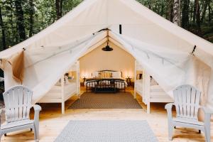 a tent with two chairs and a table at Timberline Glamping at Unicoi State Park in Helen