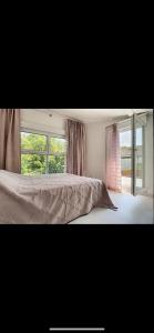 um quarto com uma cama e uma grande janela em La villa petite Camargue em Saint-Louis
