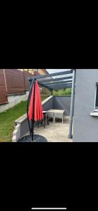 einen roten Regenschirm auf einem Tisch auf einer Terrasse in der Unterkunft La villa petite Camargue in Saint-Louis