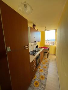 eine Küche mit einem Kühlschrank und einem Herd in der Unterkunft Monolocale PIRILÙ in Reggio di Calabria