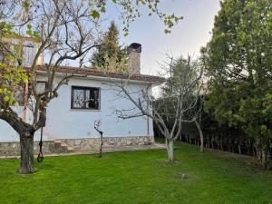 una casa blanca con un patio con árboles en Los Álamos, casa de campo cerca de Madrid, en Chiloeches