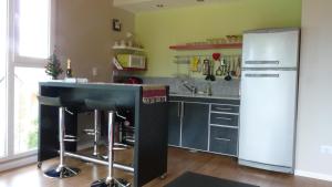 a kitchen with a black counter and a refrigerator at Apartments Seeblick Bariloche in San Carlos de Bariloche