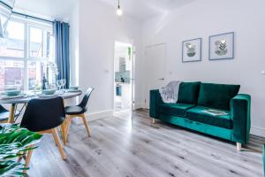a living room with a green couch and a table at Spacious 4-bed house in Crewe by 53 Degrees Property, ideal for Business & Contractors - Sleeps 7 in Crewe