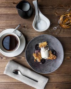 - une table avec une assiette de nourriture et une tasse de café dans l'établissement Cahkal Hotel, à Kilpisjärvi