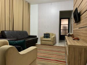 uma sala de estar com um sofá e uma cadeira em Casa 1km Anhanguera e Churrasqueira Wi-Fi em Louveira