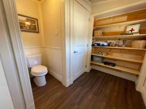 a small bathroom with a toilet and wooden floors at Bespoke Lake Cottage in New Minas +13 photos