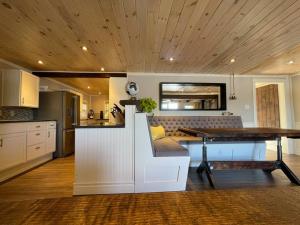 a kitchen with a table and a dining room at Bespoke Lake Cottage in New Minas