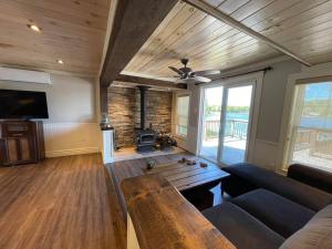 - un salon avec un canapé et une cheminée dans l'établissement Bespoke Lake Cottage, à New Minas