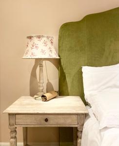 a lamp on a table next to a bed at Elmo Lodge in Salcombe