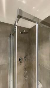 una doccia con porta in vetro e soffione di Casa Veronica nel cuore di Padova a Padova