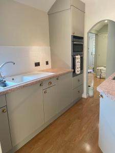 a kitchen with a sink and a stove top oven at Elmo Lodge in Salcombe