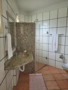 a bathroom with a sink and a shower at Pousada Villa Rosada in Santa Cruz Cabrália