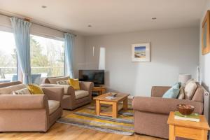 a living room with two couches and a tv at Trevone House with Hot Tub on Retallack Resort in Padstow