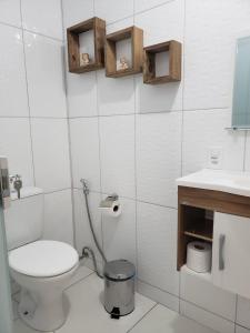 a white bathroom with a toilet and a sink at Pousada Bem Te Vi Lumiar in Lumiar
