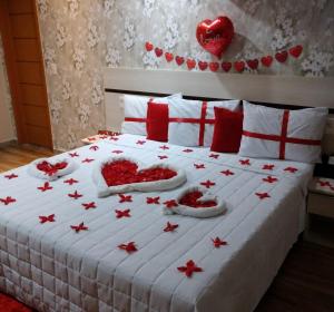 a bedroom with a bed with red and white pillows at Hotel Brisa Tropical De Macaé in Macaé