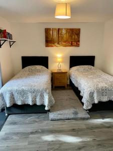 a bedroom with two beds and a table with a lamp at La Casita in Hale