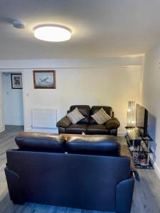 a living room with a leather couch and a television at La Casita in Hale