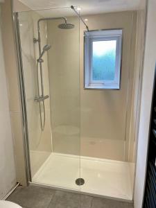 a shower with a glass door and a window at La Casita in Hale