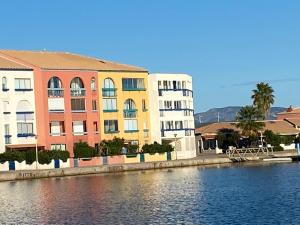 ル・バルカレスにあるAppartement en bord d'étangの水の横の建物