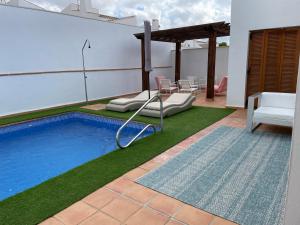 a patio with a swimming pool and a table and chairs at Villa para disfrutar en el Valle Golf Resort in Murcia