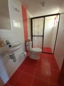 a bathroom with a toilet and a sink at HOSTAL HELICONIAS in Charalá