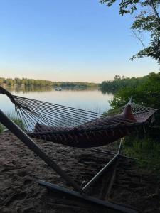 a hammock on a beach next to a lake at Leland’s Lakehouse in Wolfville
