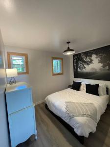 a bedroom with a bed and a dresser with a lamp at Leland’s Lakehouse in Wolfville