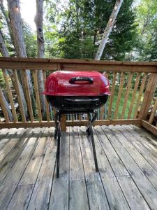 un taburete rojo sentado en una terraza de madera en Leland’s Lakehouse, en Wolfville