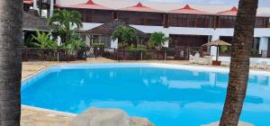 een groot blauw zwembad voor een gebouw bij Studio Lucie à MANGANAO in Saint-François