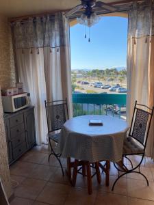 ル・バルカレスにあるAppartement en bord d'étangのテーブルと椅子と窓のあるダイニングルーム