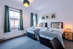 a bedroom with two beds and a window at Spacious 3-Bed house in Stoke by 53 Degrees Property, Ideal for Long Stays, FREE Parking - Sleeps 6 in Stoke on Trent