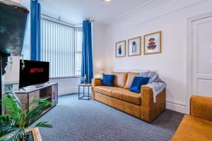 a living room with a couch and a tv at Spacious 3-Bed house in Stoke by 53 Degrees Property, Ideal for Long Stays, FREE Parking - Sleeps 6 in Stoke on Trent