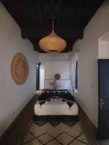 a bedroom with a bed in the corner of a room at Charmant riad pour familles ou groupes - Dar Mama in Essaouira