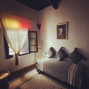 a bedroom with a bed and a window at Charmant riad pour familles ou groupes - Dar Mama in Essaouira