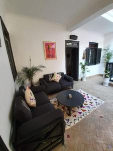 a living room with a couch and a table at Charmant riad pour familles ou groupes - Dar Mama in Essaouira +33 photos