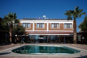 a hotel with a swimming pool in front of a building at TUNA OTEL in Gelibolu