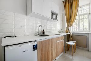 a white kitchen with a sink and a dishwasher at KayKay Apartments in Odesa