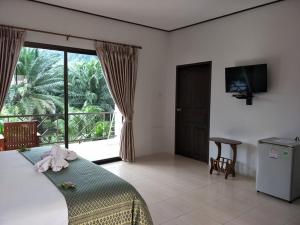 sypialnia z łóżkiem i dużym oknem w obiekcie Sawasdee Home Stay Resort & Pool w mieście Khao Lak