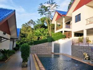 a house with a swimming pool next to a building at Sawasdee Home Stay Resort & Pool in Khao Lak