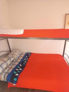 two bunk beds in a room with a red mattress at Hostal Cafe San Bernabe in Bogotá