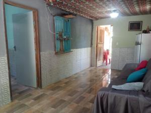 ein Wohnzimmer mit einem Sofa in einem Zimmer in der Unterkunft Hospedaria Recanto da Paz in Itaporanga dʼAjuda
