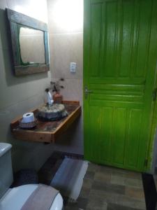 eine grüne Tür im Bad mit WC in der Unterkunft Hospedaria Recanto da Paz in Itaporanga dʼAjuda