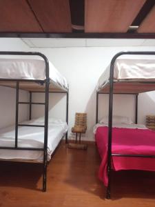 two bunk beds in a room with a red blanket at Hostal Cafe San Bernabe in Bogotá