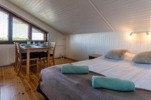 ヤストシェンビャ・グラにあるVilla Linneのベッド2台、テーブル、ダイニングルームが備わる客室です。