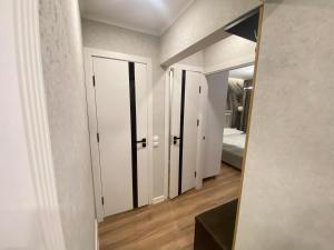 a hallway with white closet doors and a mirror at Sweethome Ciocana in Chişinău