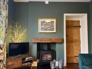 a living room with a fireplace and a television at Horse Market Cottage Kirkby Lonsdale in Kirkby Lonsdale