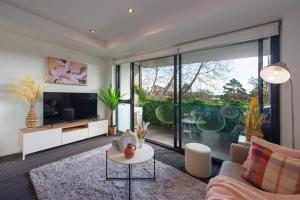 uma sala de estar com um sofá e uma televisão em Trendy 2 bed 2 bath Apartment - Heart of St Kilda em Melbourne